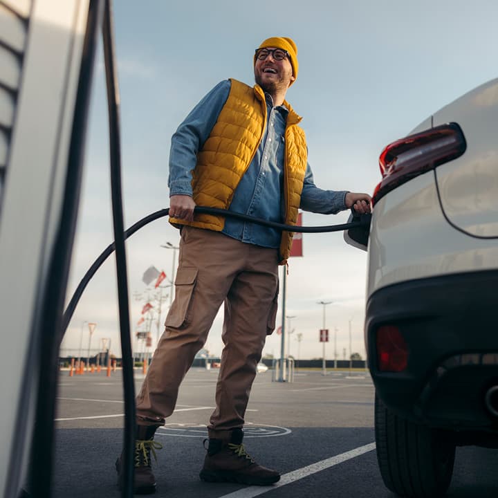 Man with yellow vest charging EV portrait