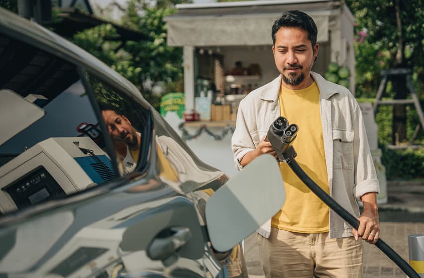 Man with beard charging EV summer